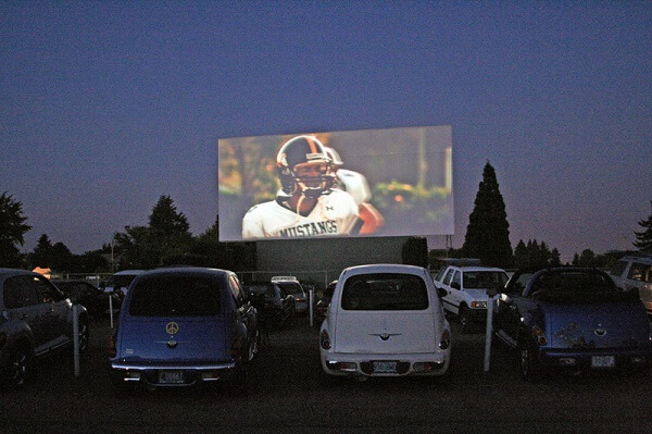 two cars sit at a drive in movie in Walla Walla valley