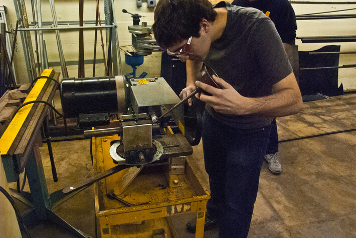 student working on a solar car in a quirky iowa club