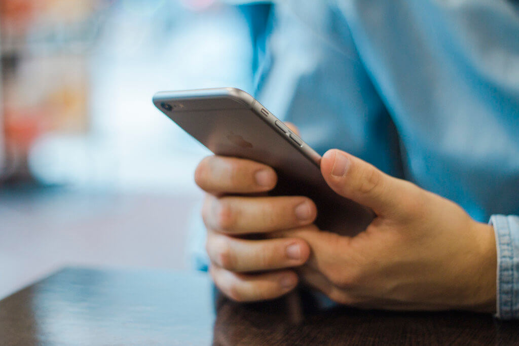 A man's hands hold a smartphone. 