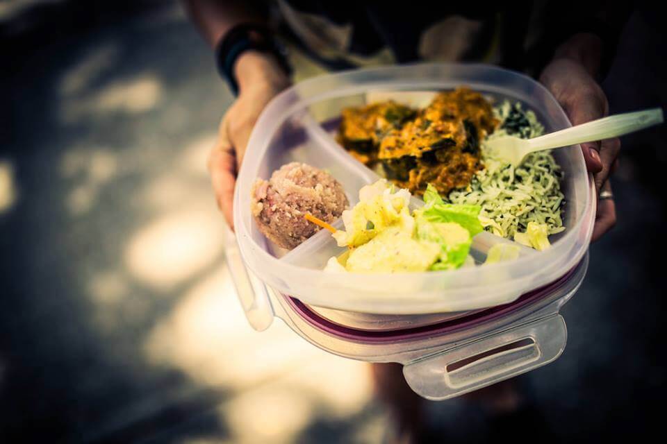 Tupperware filled with Krishna Lunch in Gainesville, complete with vegetables, salad, and a scoop of halava.