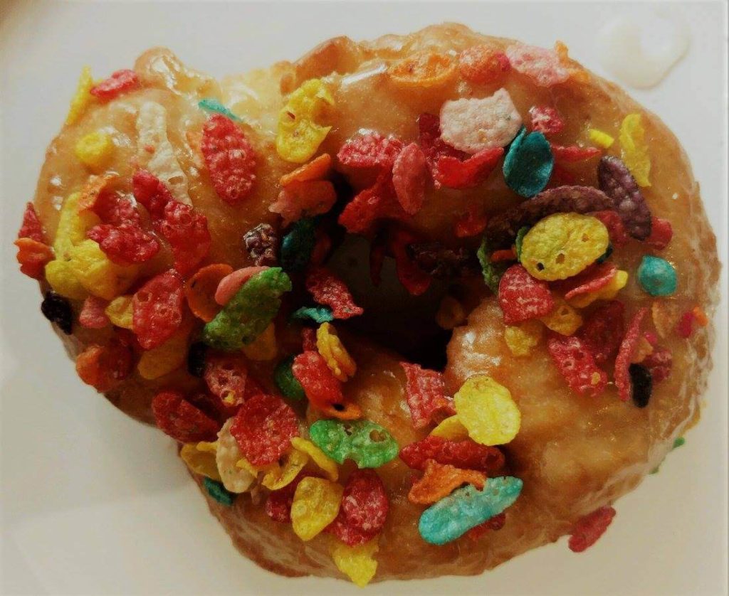 A Gator Baked in Gainesville donut topped with Fruity Pebbles cereal.