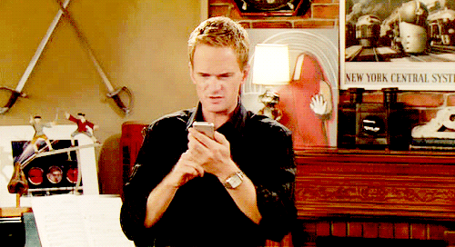 Neil Patrick Harris looks at his app on his iPhone confused 