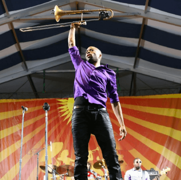 A musician holds up his trombone at Jazz Fest in NOLA.