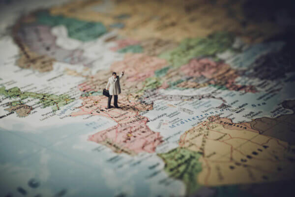 Figurine of man standing on a world map, ready to take on the world.