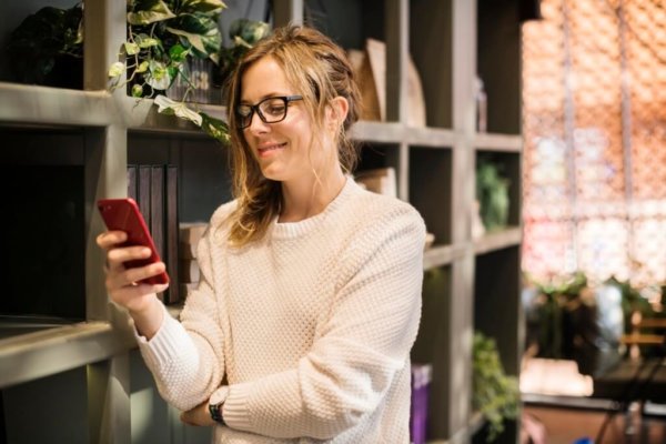 woman checks phone and smiles