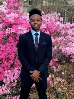 Tulane Student in front of pink flowers