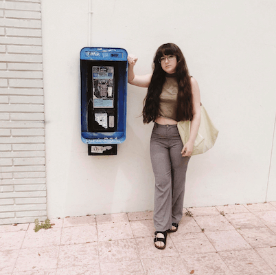 Tulane student in front of a phone booth