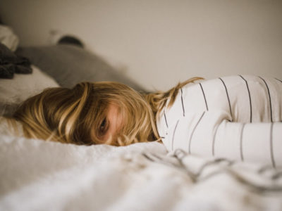 girl lying face down on bed