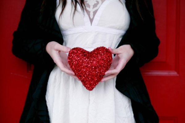 How to ask a shy guy out- woman holding a red heart.