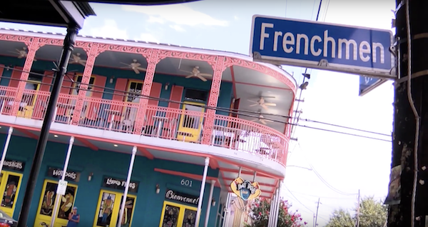 A shot of Dat Dog in the background and a street sign of Frenchman street in the foreground new orleans