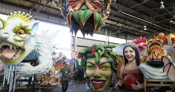 Man standing next to floats at Mardi gras world New Orleans