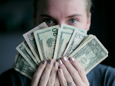 Person holding cash fanned out in two hands