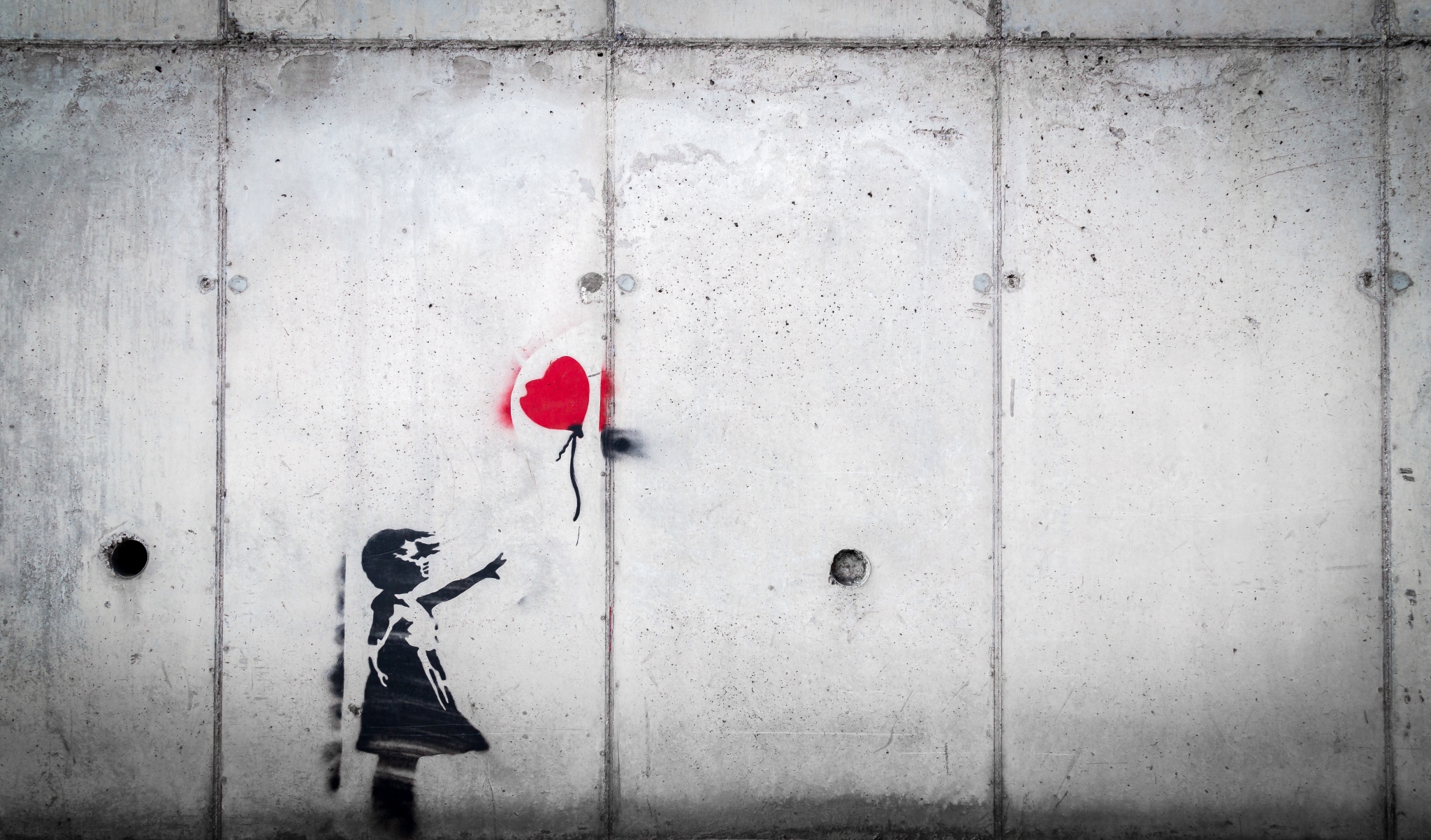 girl reaching for red heart balloon