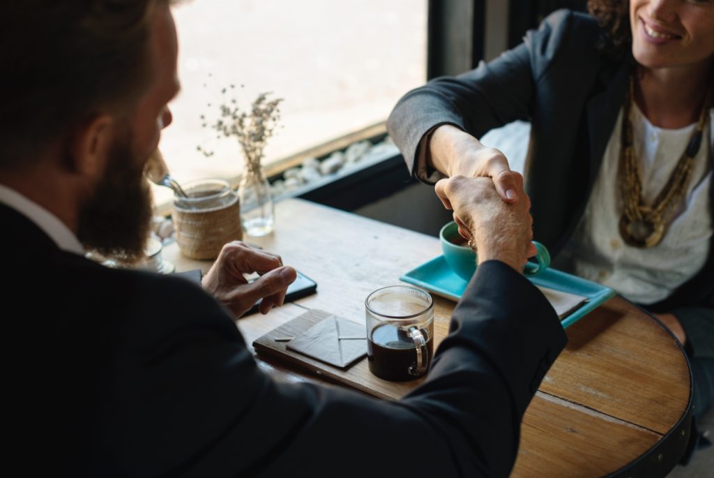 man and woman shaking hands interpersonal skills