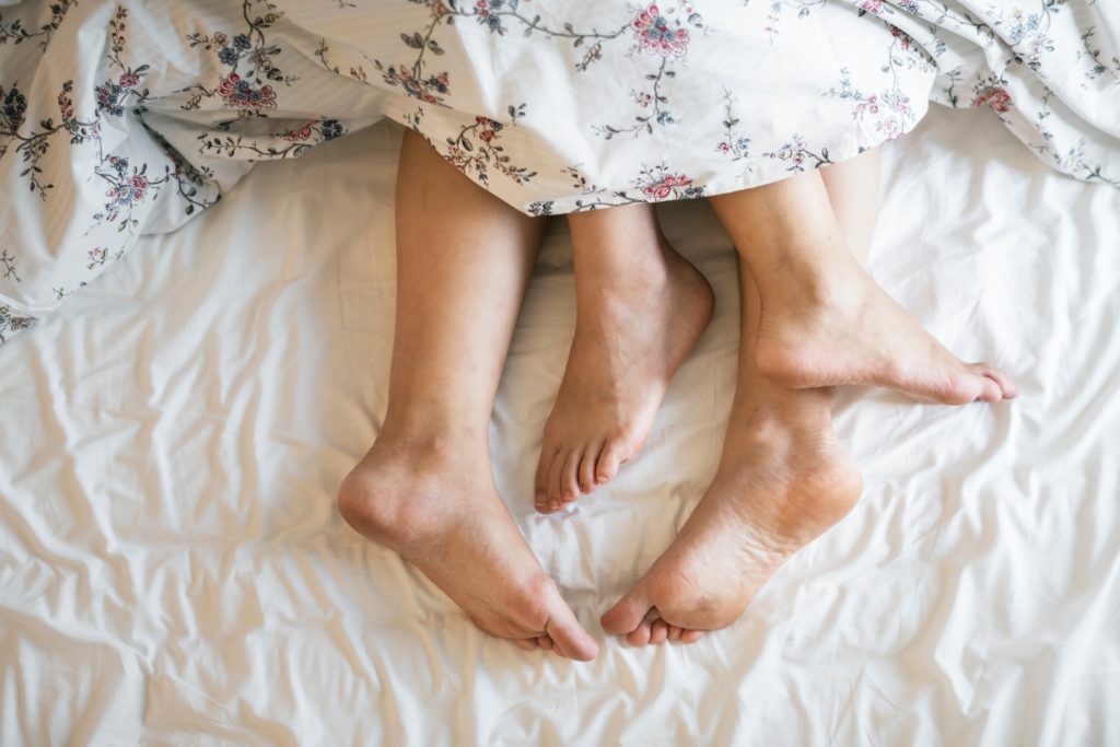 feet of a couple in bed