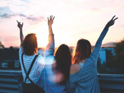 Friends smiling with hands in air