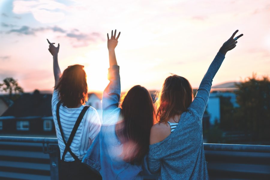 Friends smiling with hands in air