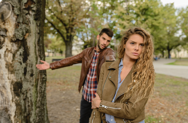 Woman turning away from man after fight dating in college