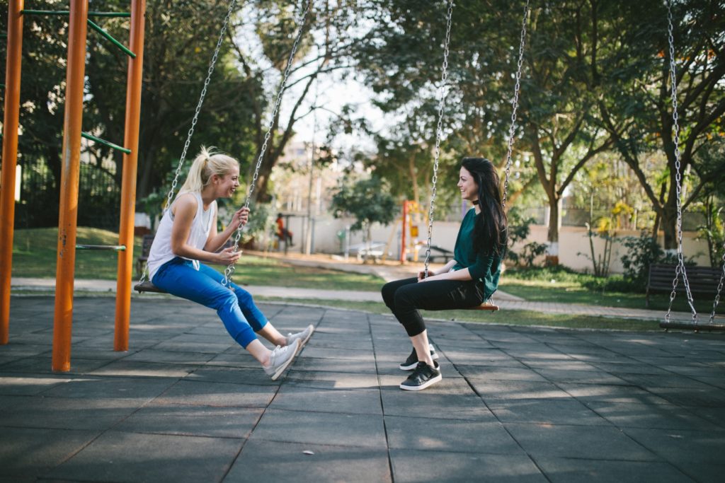 friends on swings laughing