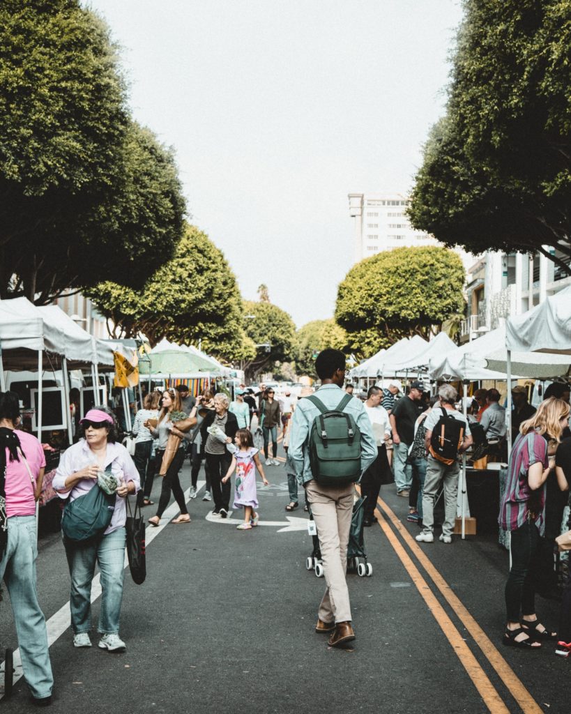 walking down street with backpack farmer's market