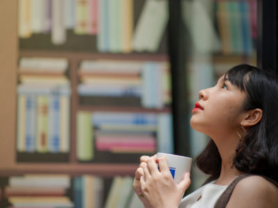 Woman looking up in front of book shelves