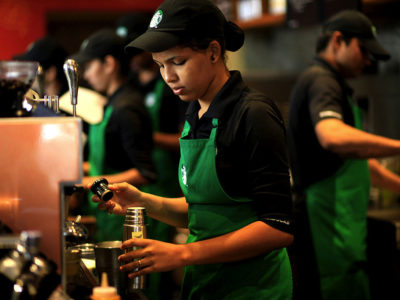 Barista prepares coffee for customers.