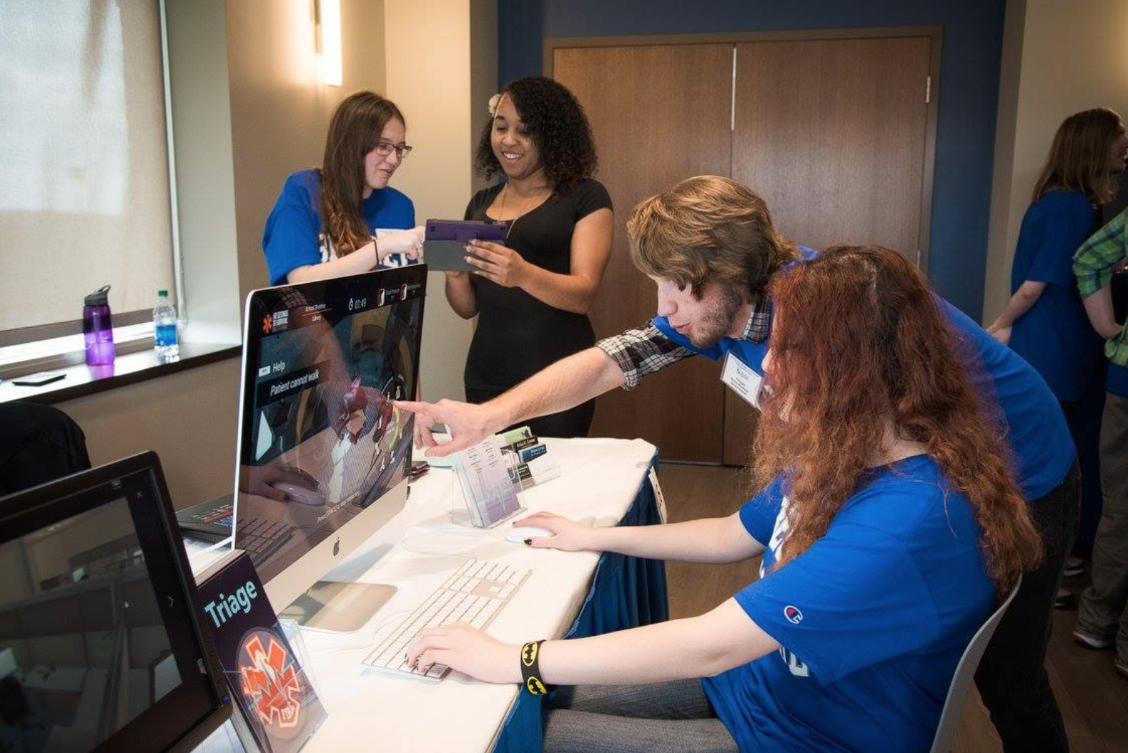student helping another student with her game design project on her computer