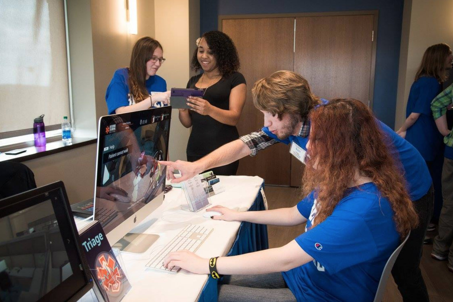 student helping another student with her game design project on her computer 