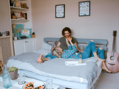 Guy and girl enjoying and eating pizza at home