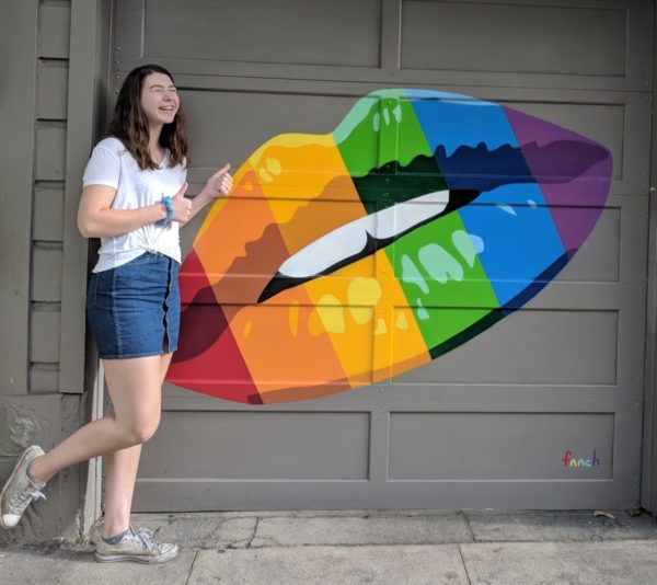 Megan standing in front of rainbow colored lips