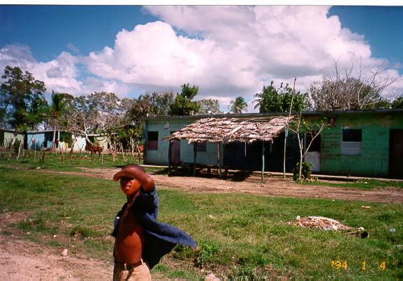 photo of a child standing in front of a house in Batey, Dominican Republic