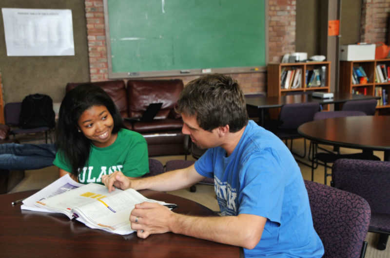 A student sits with their tutor.