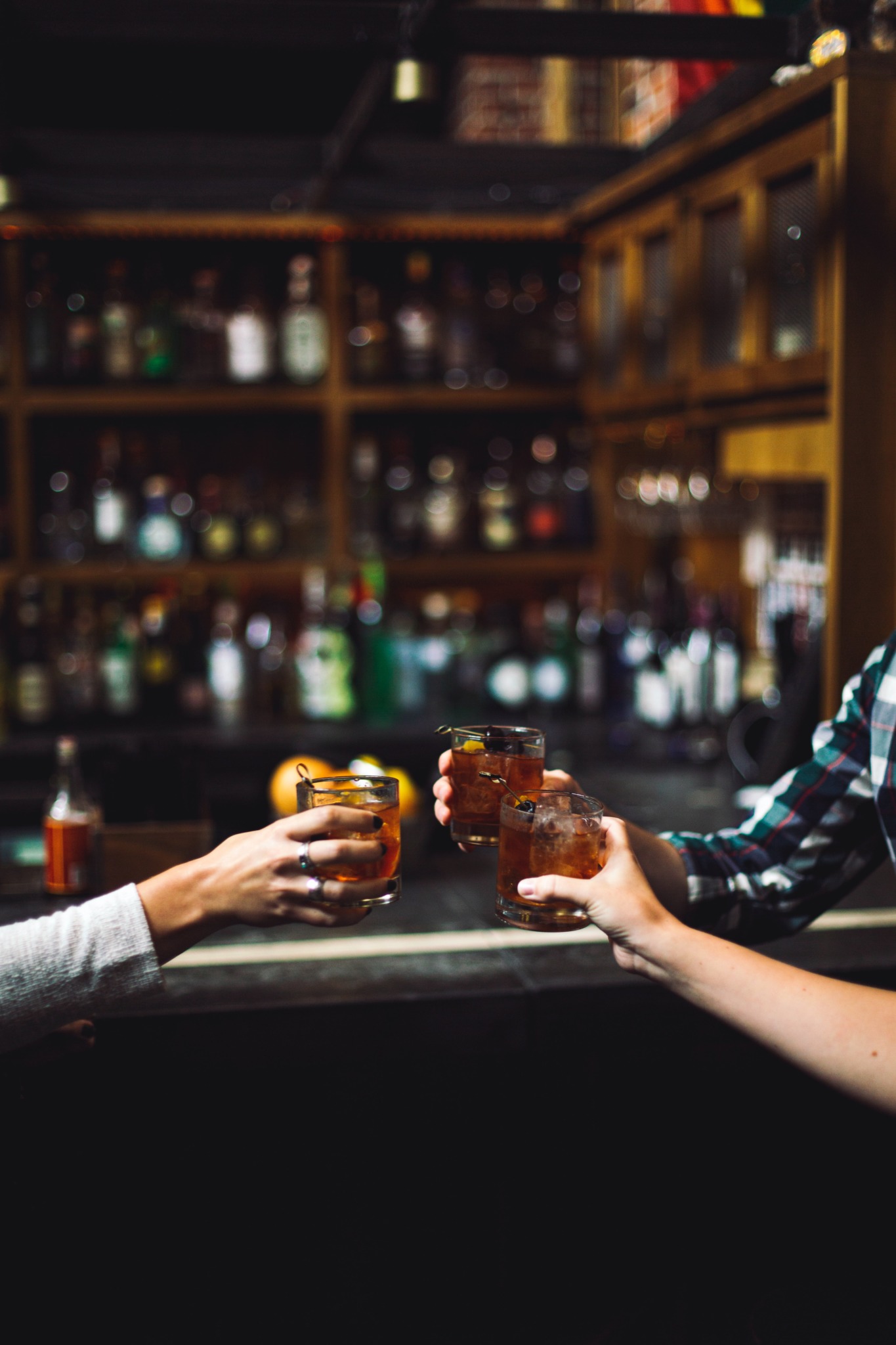 people clinking drinks at a bar