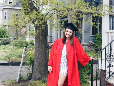 Amanda Pliszack stands in front of her home in her graduation cap and gown