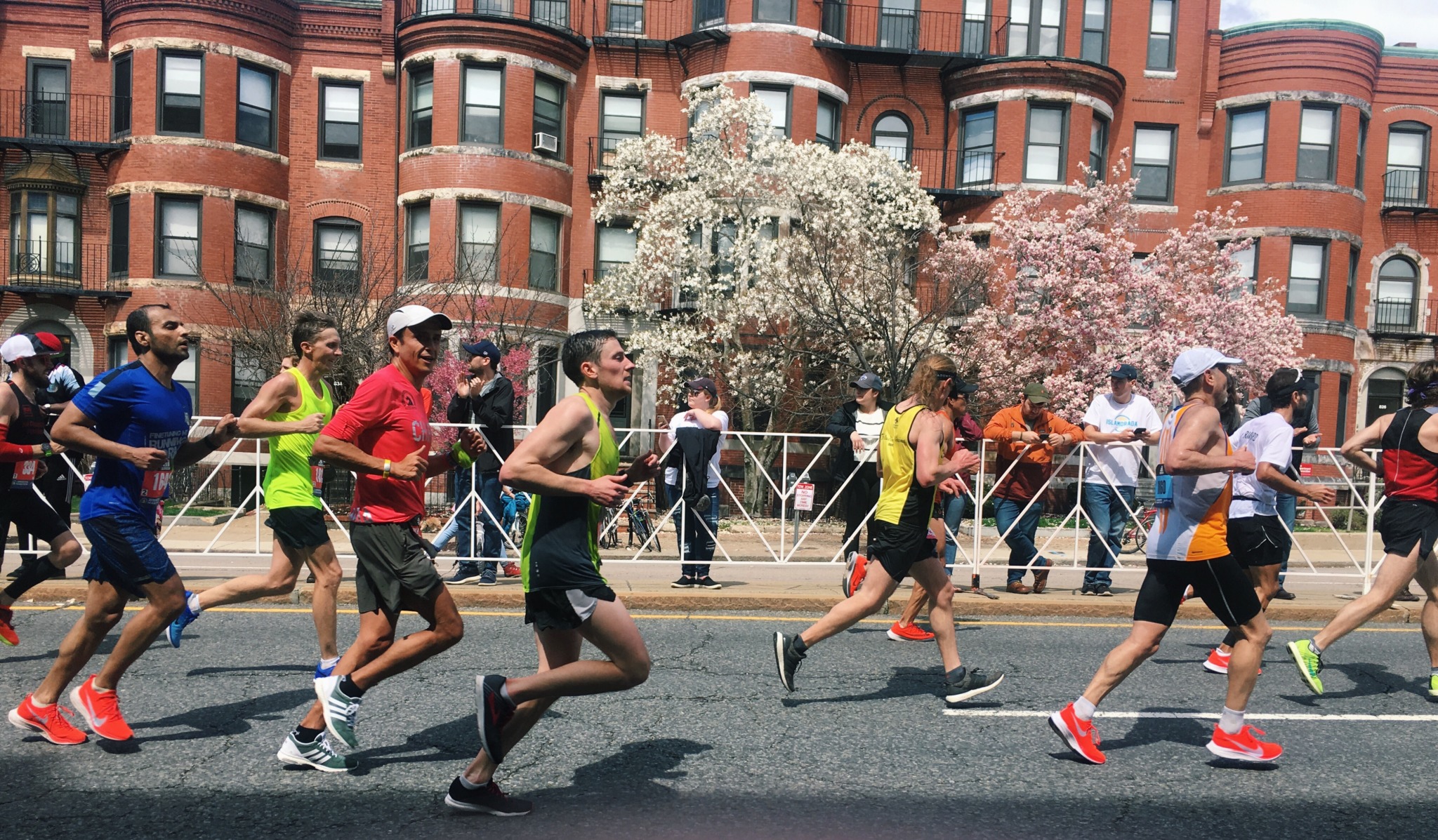 a group of runners passing by while competing in the Boston Marathon