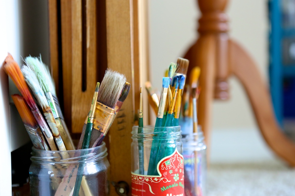 photo of paintbrushes in glass mason jars