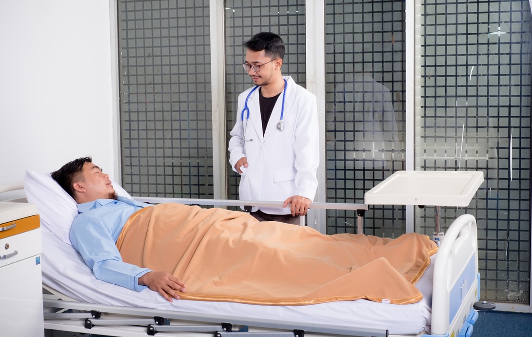 A psychiatrist consults with a patient in their hospital bed