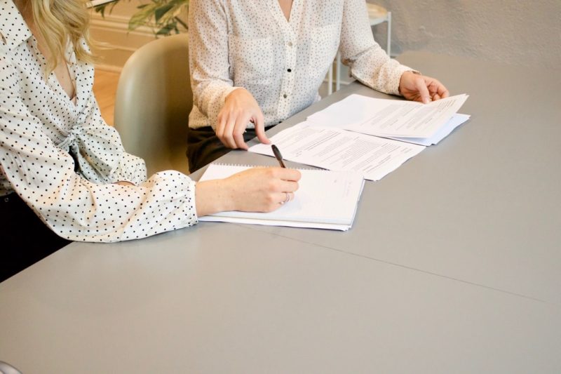 Two people look over a cover letter and resume