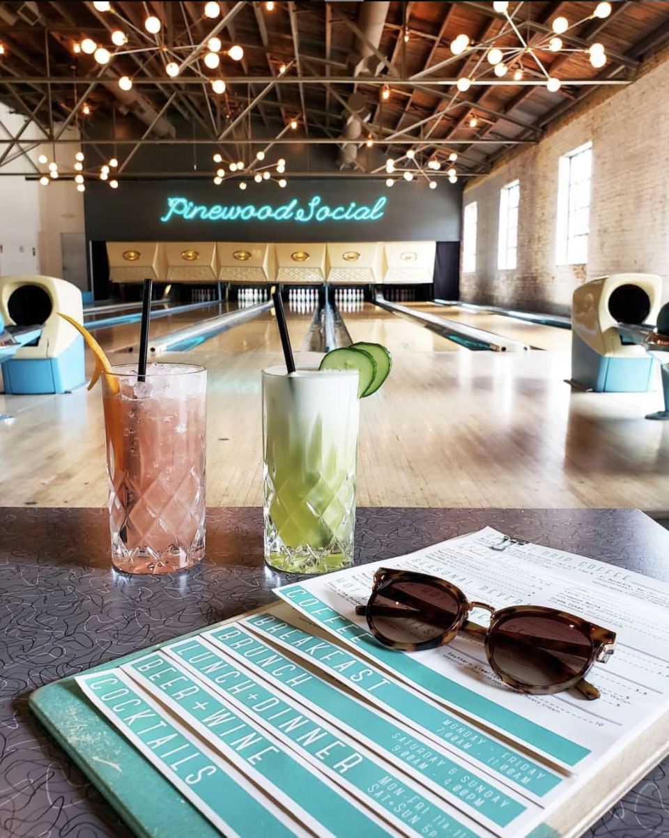 two smoothies sitting on a table in an empty bowling alley