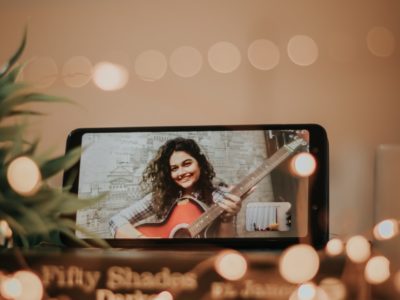 girl social distancing on FaceTime playing guitar