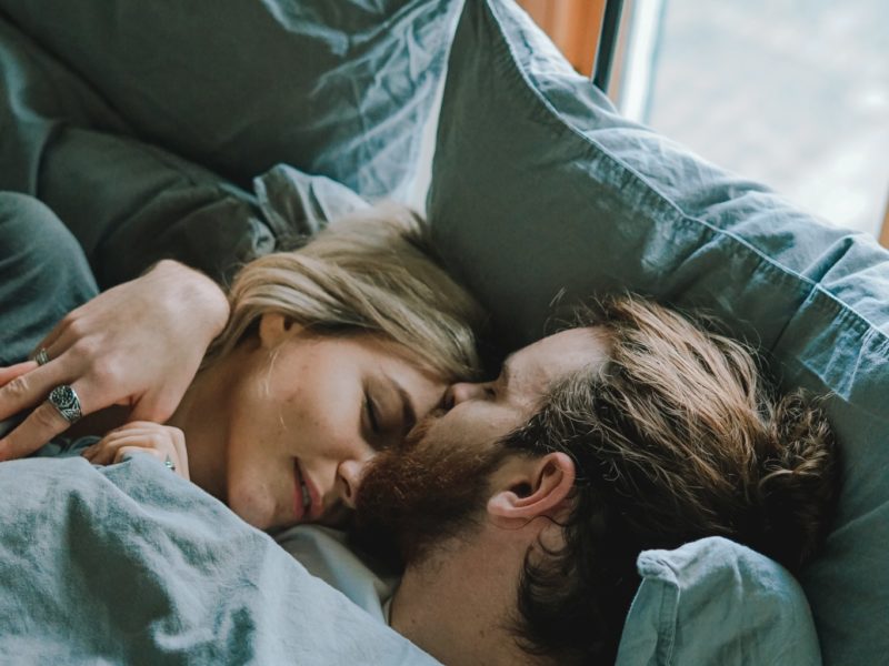 man kissing woman