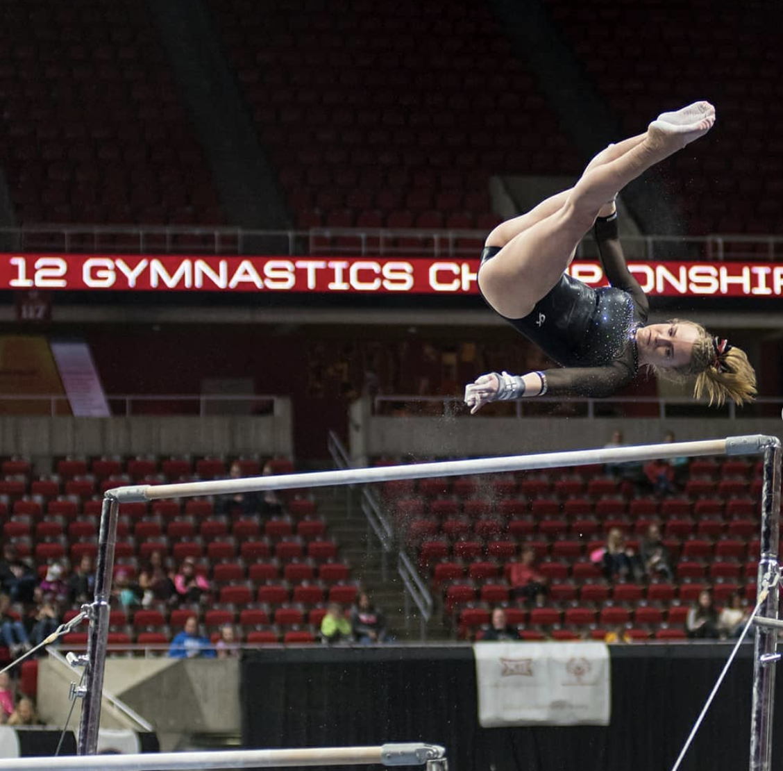 a gymnast flipping on the uneven bars