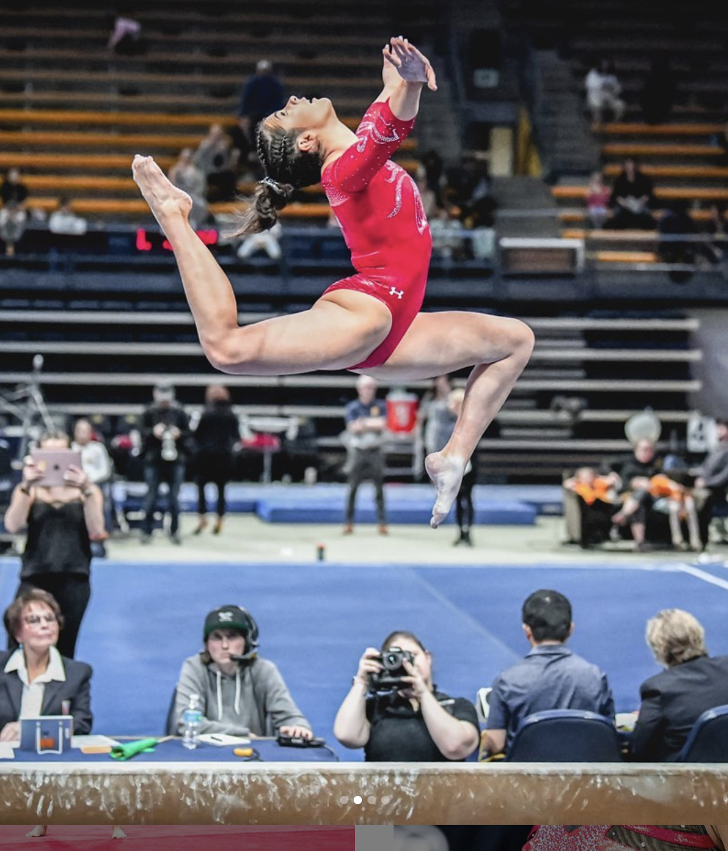 a gymnast jumping on the balance beam