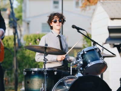 Man with glasses playing a drum set.