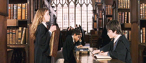 hermione throwing book on top of harry potter's hands
