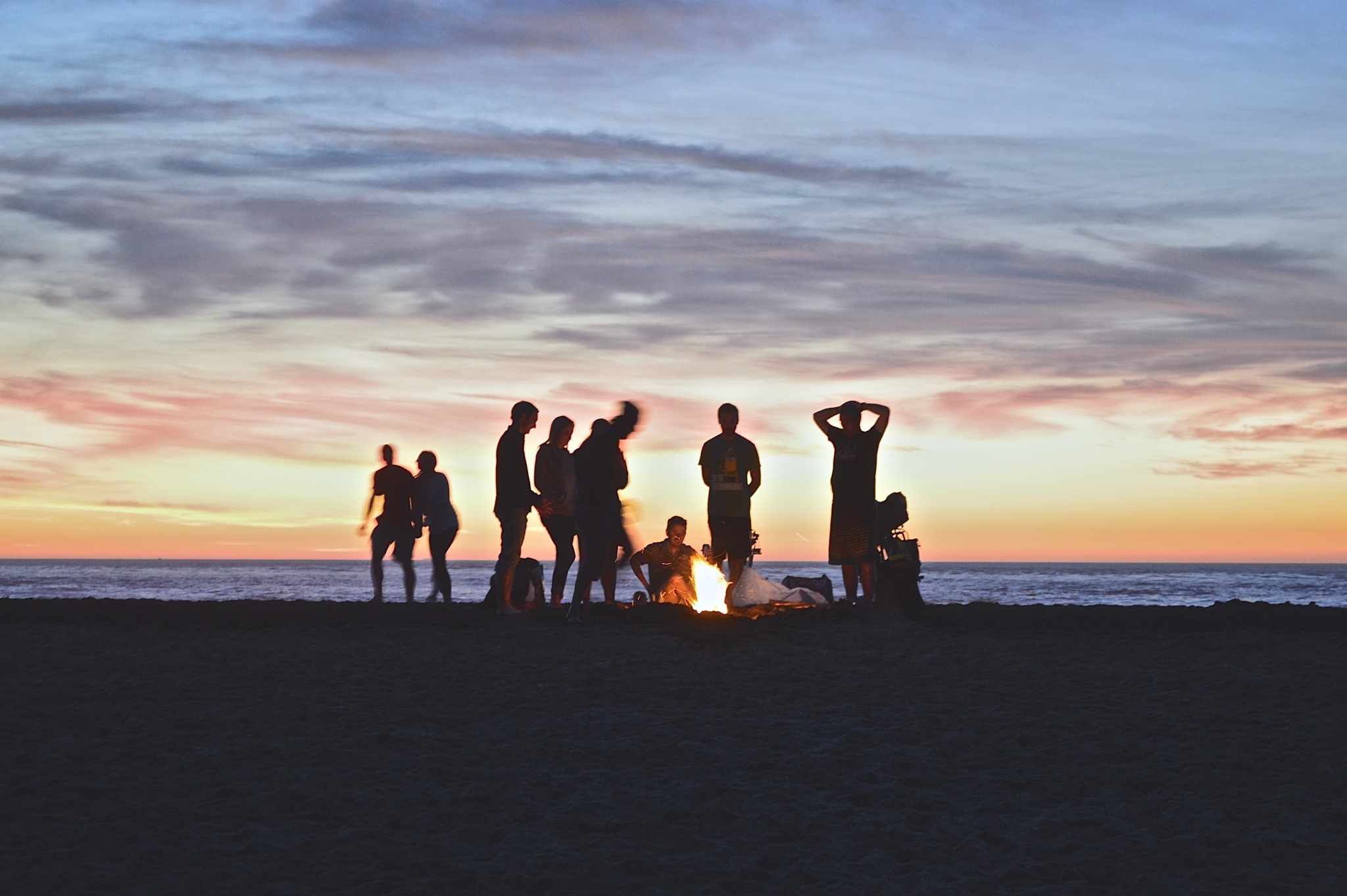 people at a beach bonfire