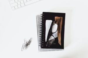 glasses on top of notebooks and books