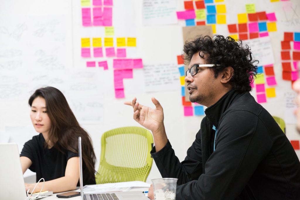 two people and a whiteboard behind them