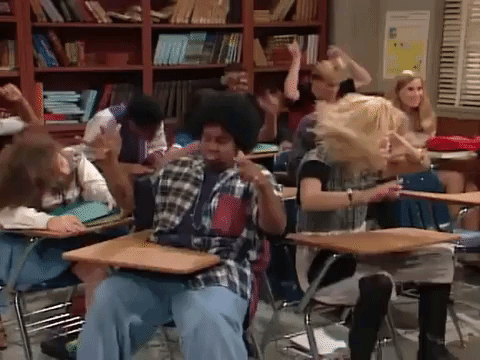 kids dancing while sitting in school desks