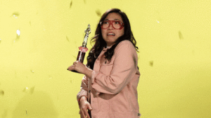 girl scared by confetti with award in hand